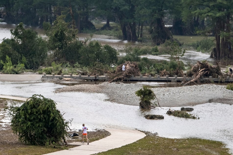 Ein Jogger macht einen Umweg um einen überfluteten Laufweg im Louise Hays Park in Kerrville.