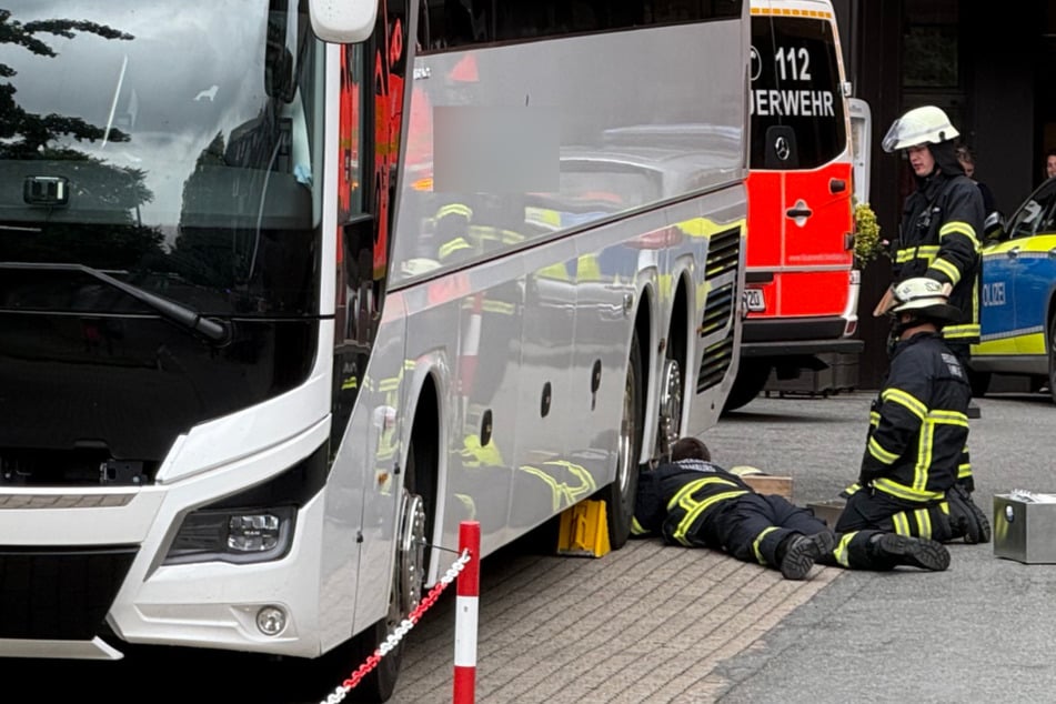 Nahe Hotel: Pannenhelfer unter Reisebus eingeklemmt, Feuerwehr im Einsatz