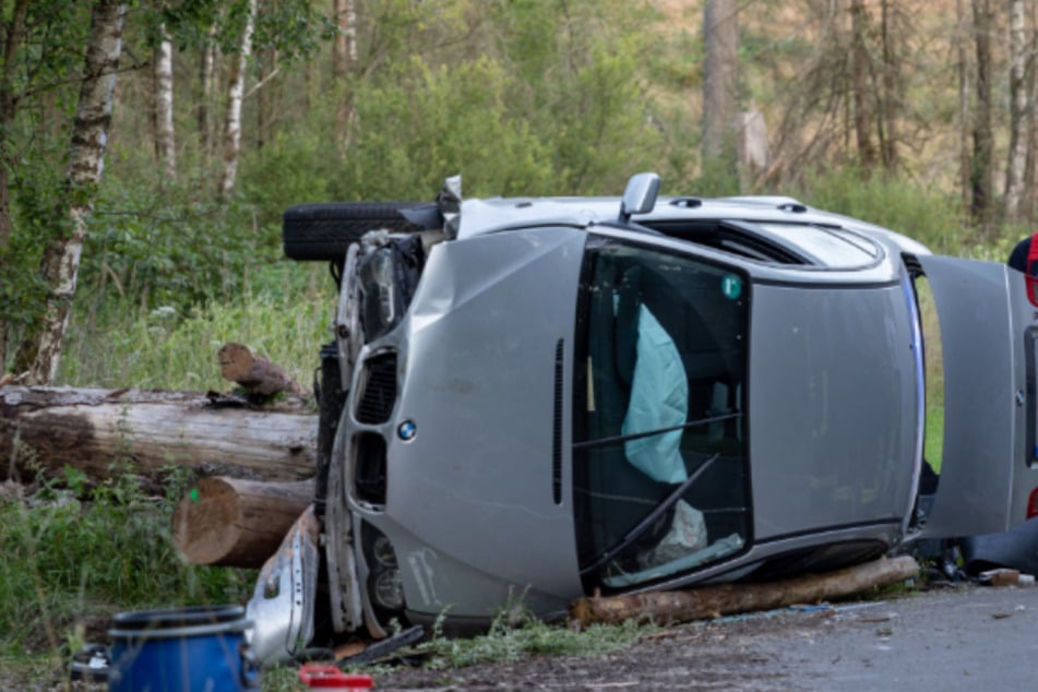 Zu schnell unterwegs? BMW kracht gegen Holzstoß und kippt um
