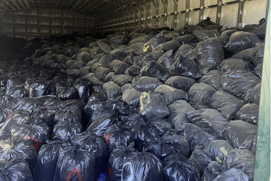 Trash bags containing over 90,000 pounds of marijuana valued at $100 million are recovered during a search warrant by San Bernardino County Sheriff's Department Marijuana Enforcement Team on December 9, 2024, in Oak Hills, California.