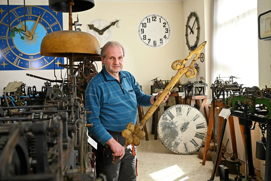 Der Chef vom Uhrenmuseum Dirk Röder (56) hält einen goldenen Turmuhrenzeiger in seinen Händen.