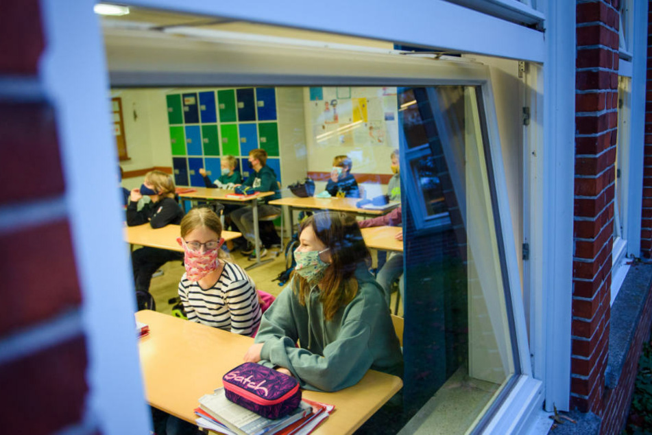 Schüler sitzen mit Maske und bei geöffnetem Fenster im Unterricht. Für die Kultusministerkonferenz stehe die Frage Präsenzunterrichts während der Corona-Pandemie ganz oben auf der Agenda. (Symbolfoto)