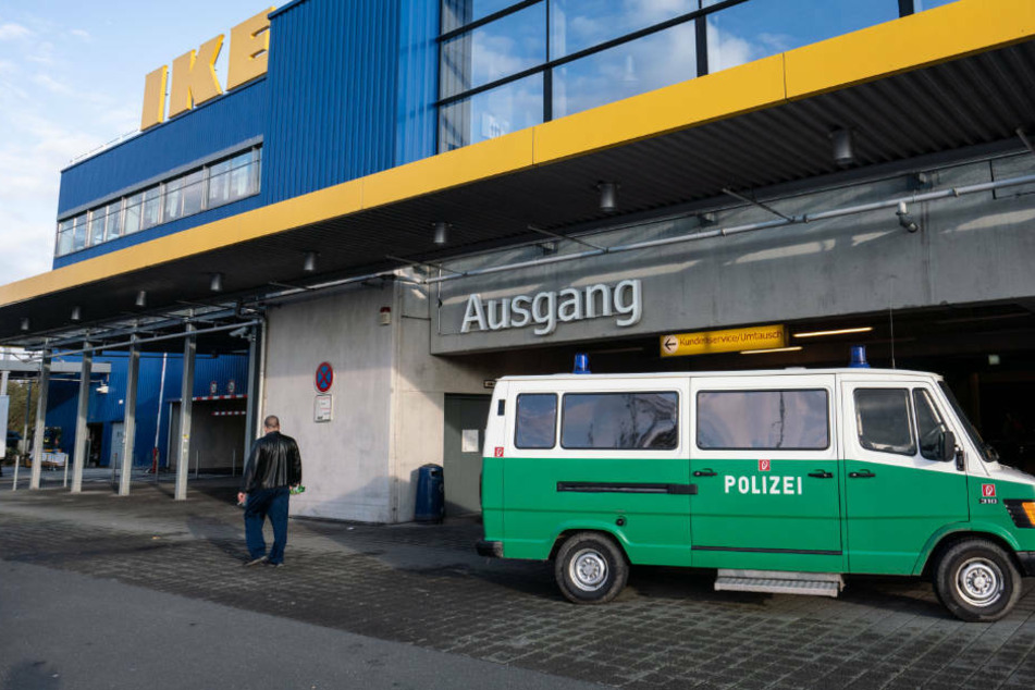 Ein Fahrzeug der Spurensicherung der Polizei steht vor einem Seiteneingang eines Ikea-Möbelhauses im Stadtteil Nieder-Eschbach, nachdem hier ein Geldbote angeschossen und schwer verletzt worden war (Archivbild).