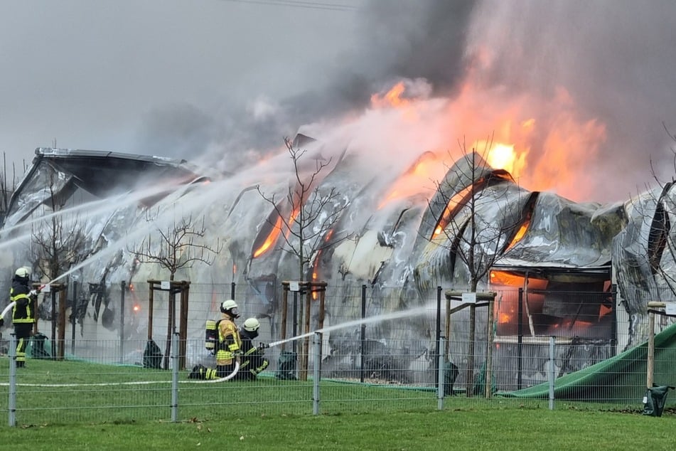 Während die Feuerwehr gegen die Flammen kämpft, sollen Anwohner dringend Fenster und Türen geschlossen halten.