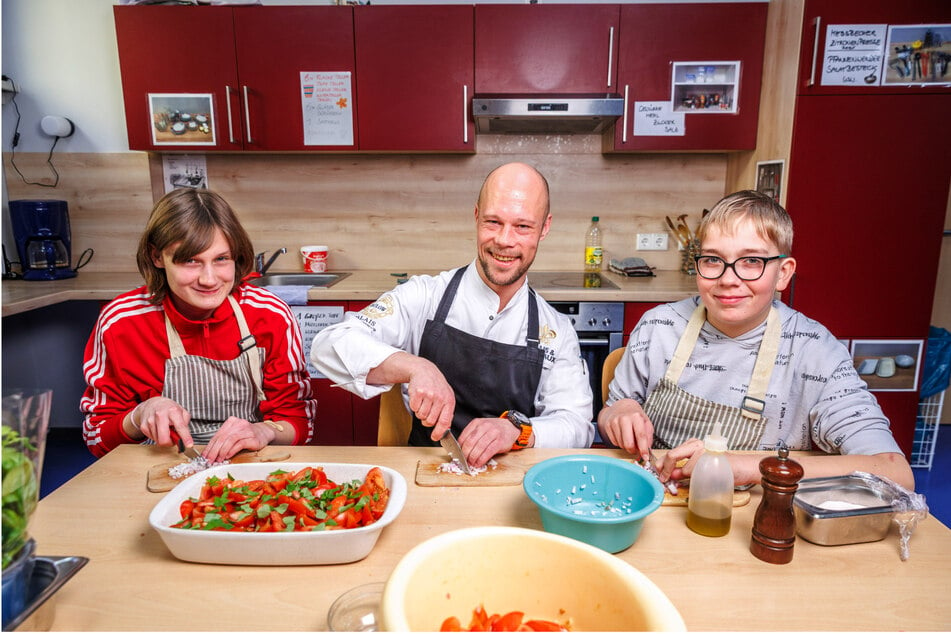 Chefkoch Sven Vogel (37) schnippelt mit Luca-Noel (12) und Leonie (15) einen leckeren Salat.