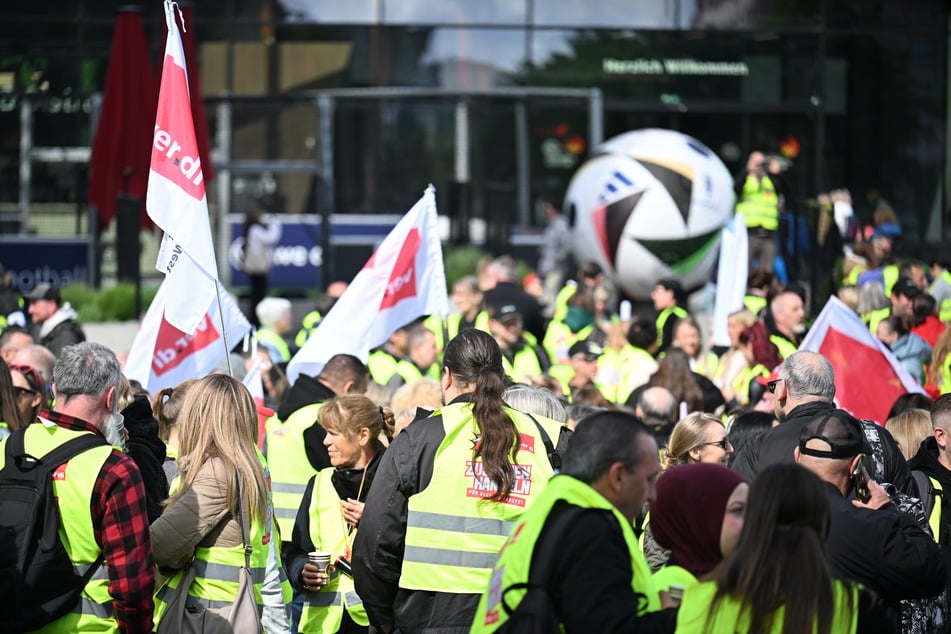 Beschäftigte im Einzelhandel demonstrieren mit Fahnen vor dem Fußball-Museum in Dortmund.