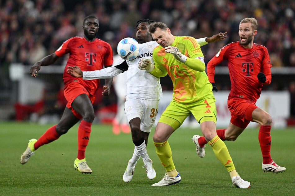 Manuel Neuer (2.v.r.) hat beim DFB-Pokal-Kracher zwischen dem FC Bayern und Bayer Leverkusen Gegenspieler Jeremie Frimpong abgeräumt.