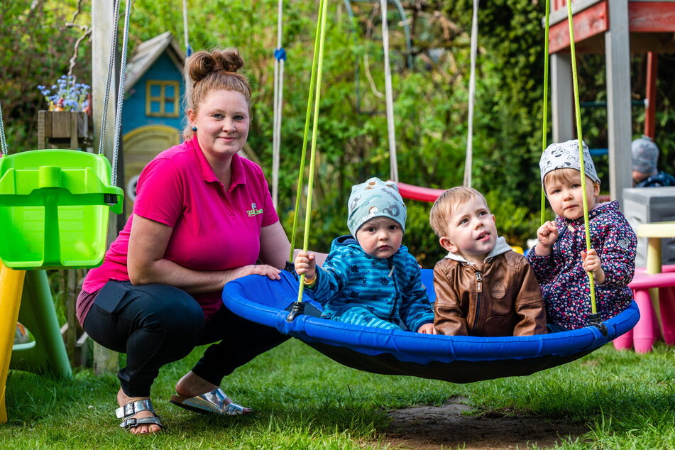Schaukeln im Garten: Tagesmutter Katja Kamprath (35) mit Mika (2), Adrian (3) und Finja (3).