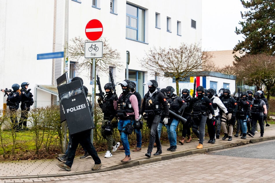 Einsatzkräfte der Polizei sichern das Gelände rund um die Berufsschule ab und bereiten sich auf ihren Einsatz vor.