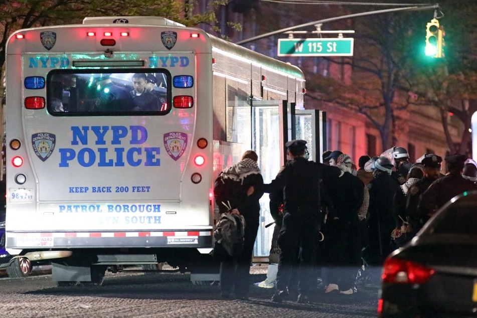 NYPD officers arrest students and load them into a bus as they evict a building that had been occupied by pro-Palestinian protesters at Columbia University.