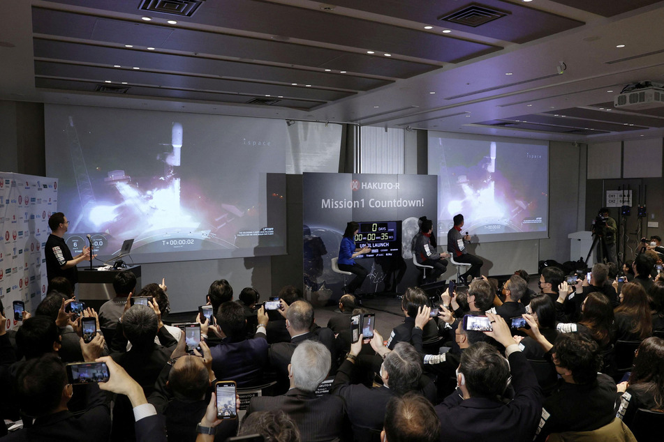 Officials of ispace Inc's HAKUTO-R mission in Tokyo, Japan, look at live broadcasting of the launch of a SpaceX Falcon 9 rocket at Cape Canaveral Space Force Station.