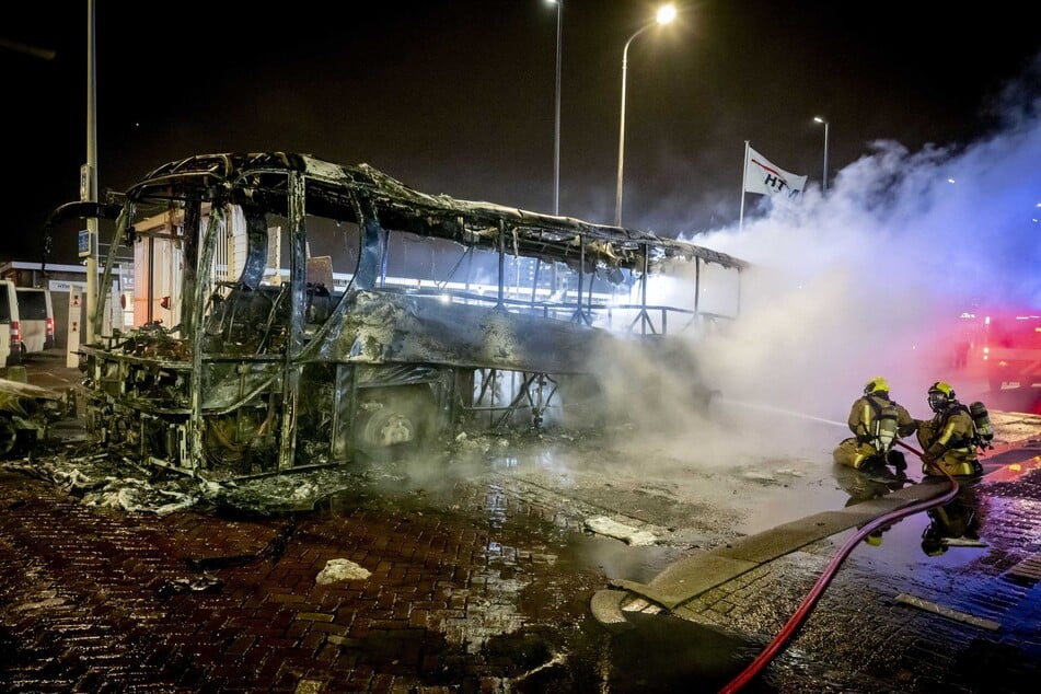 Ein Bus am Opernhaus brannte: Feuerwehrleute bekämpfen die Flammen.