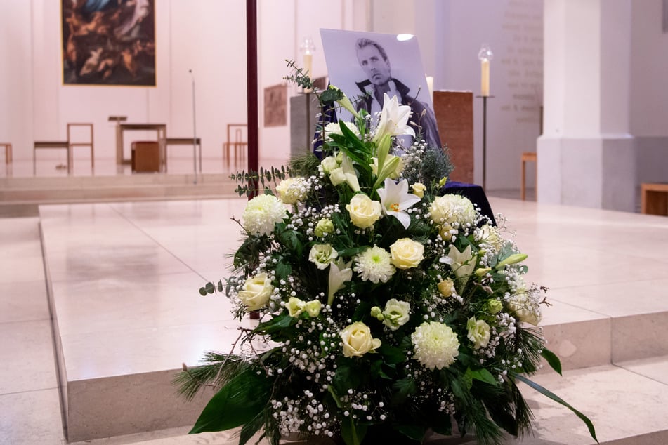 Blumen und ein Bild von Siegfried Fischbacher stehen vor Beginn der Trauerfeier für den verstorbenen Magier in der Kirche St. Nikolaus.