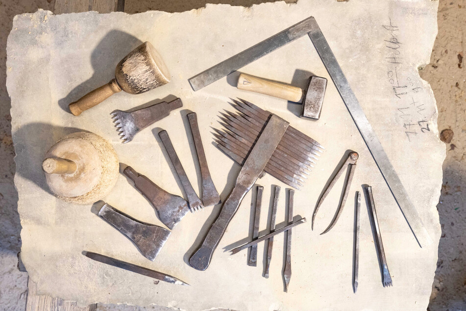 Die Steinmetze der Bauhütte arbeiten mit handgeschmiedeten Werkzeugen und hölzernen Knüpfeln (F.r.): Wind und Wetter setzen dem Sandstein zu.