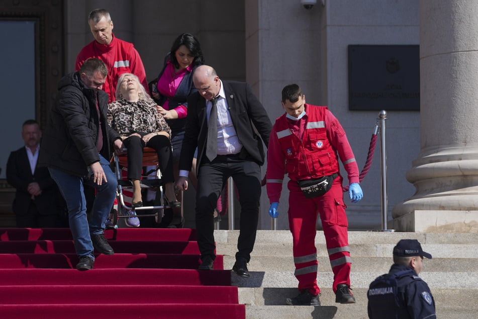 Sanitäter tragen eine verletzte Abgeordnete aus dem Parlament.