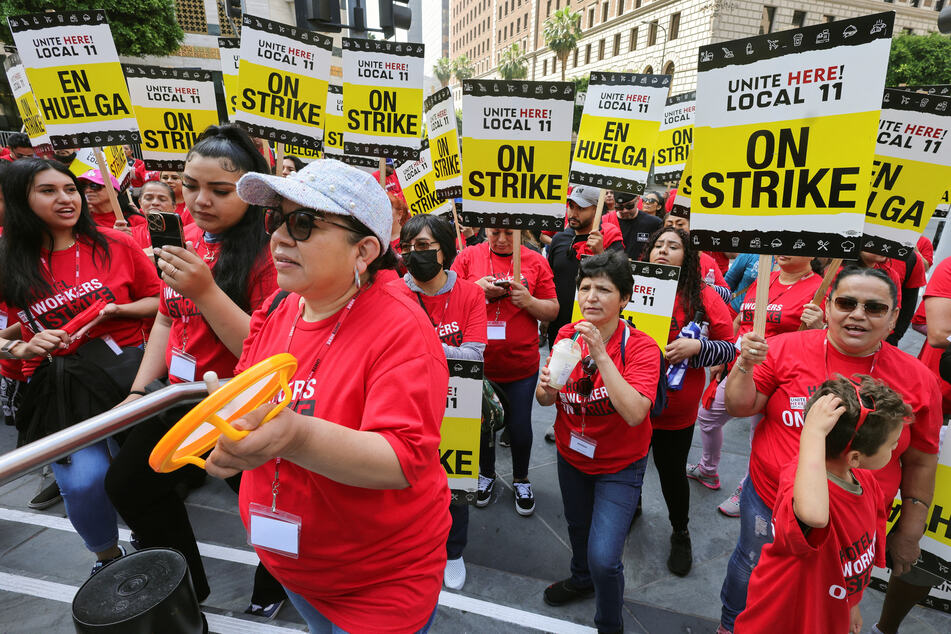 People protest in front of the InterContinental Hotel in Los Angeles as unionized hotel workers in Southern California go on strike.