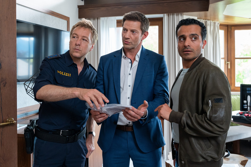 Polizeihauptmeister Mohr (Max Müller 58, l.) zeigt den Kommissaren Hansen (Igor Jeftić, 52, M.) und Kaya (Baran Hêvî, 37, r.) den gefundenen Businessplan.