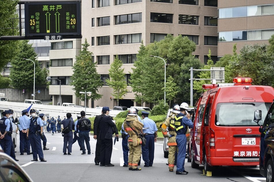 Polizei und Feuerwehrleute inspizieren den Ort, an dem sich ein Mann in der Nähe des Büros des Premierministers in Tokio selbst in Brand setzte.