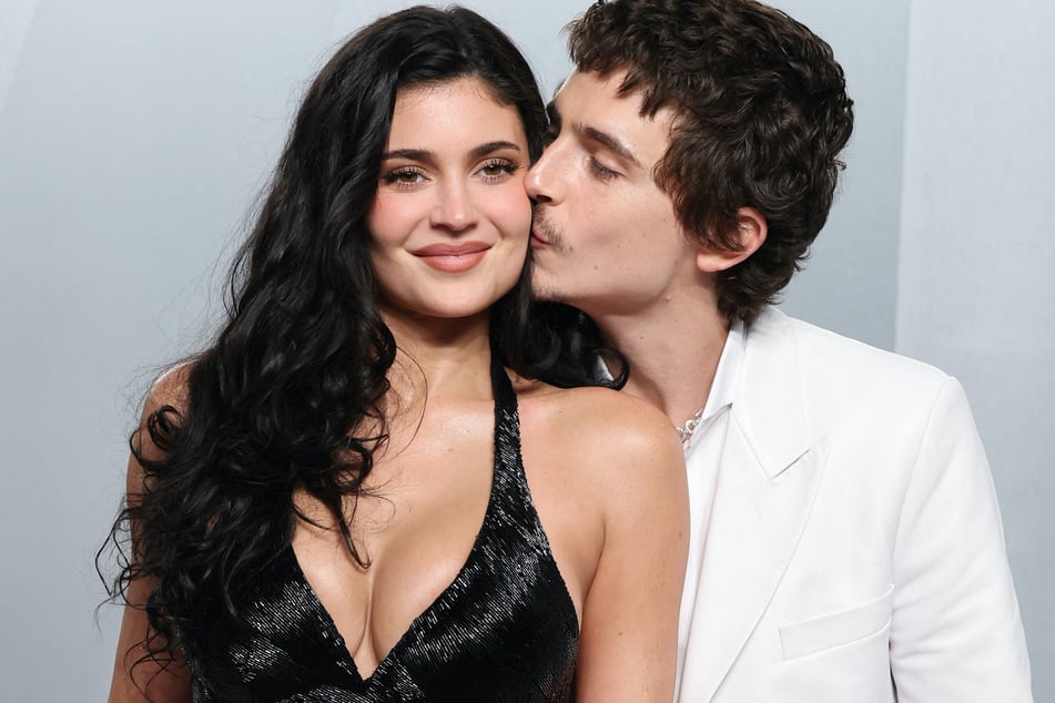 Kylie Jenner gets a sweet kiss from Timothée Chalamet (r.) at the Oscars Vanity Fait afterparty.