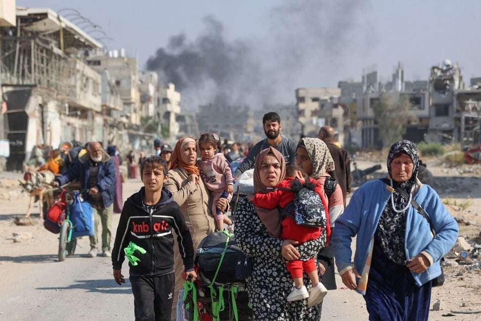 Palestinians forcibly displaced from shelters in Beit Hanoun cross the main Salaheddine road into Jabalia in the northern Gaza Strip following Israeli army evacuation orders.