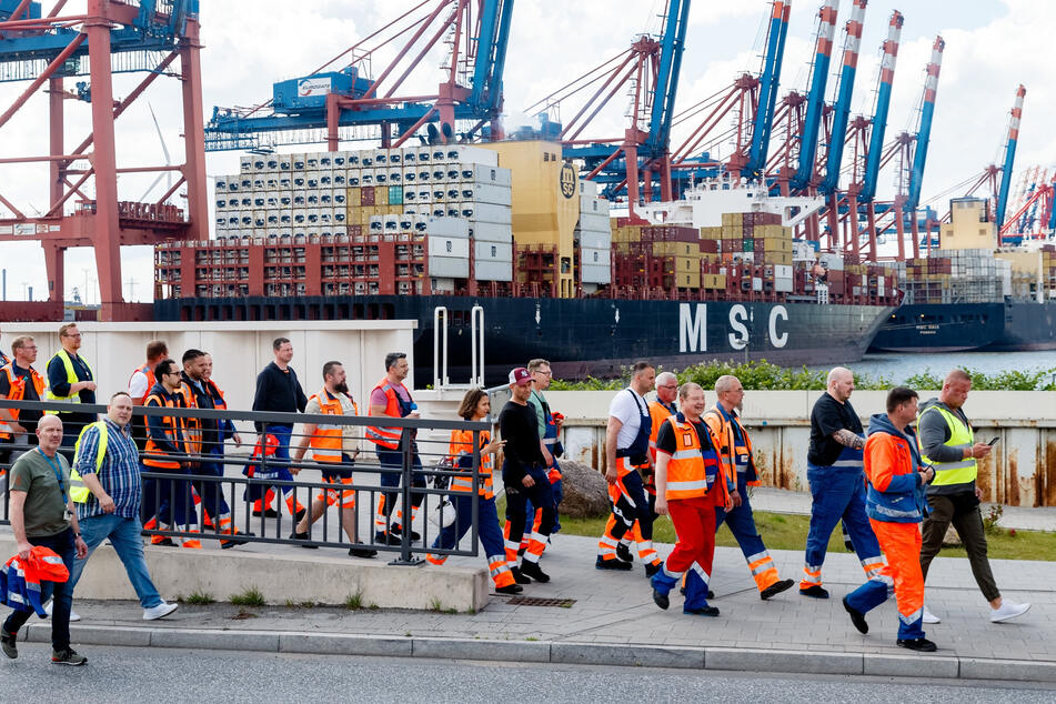 Hafenarbeiter gehen in Hamburg zu einer Streikversammlung.