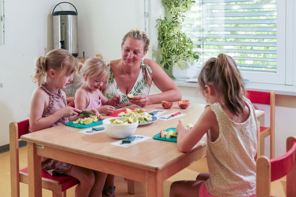 Erzieherin Nicole Klein (40) erklärt den Kindern, worauf es beim Obstschneiden ankommt und warum Vorsicht geboten ist.