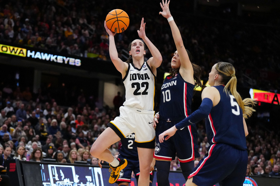Iowa Hawkeyes guard Caitlin Clark (22) shoots against Connecticut Huskies guard Nika Muhl (10) and guard Paige Bueckers (5) in the second quarter in the semifinals of the Final Four of the women's 2024 NCAA Tournament.