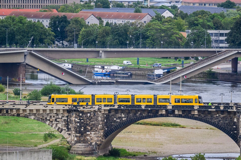 Während die Straßenbahnen über die Augustusbrücke fahren, ist ein Teil der Carolabrücke eingestürzt.