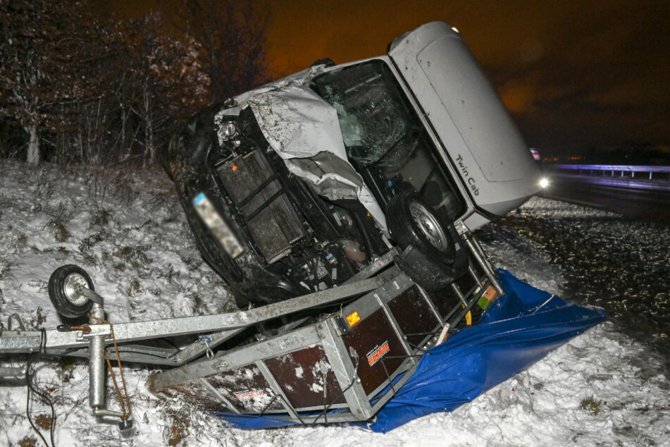 Der Transporter liegt auf dem völlig zerquetschten Anhänger.