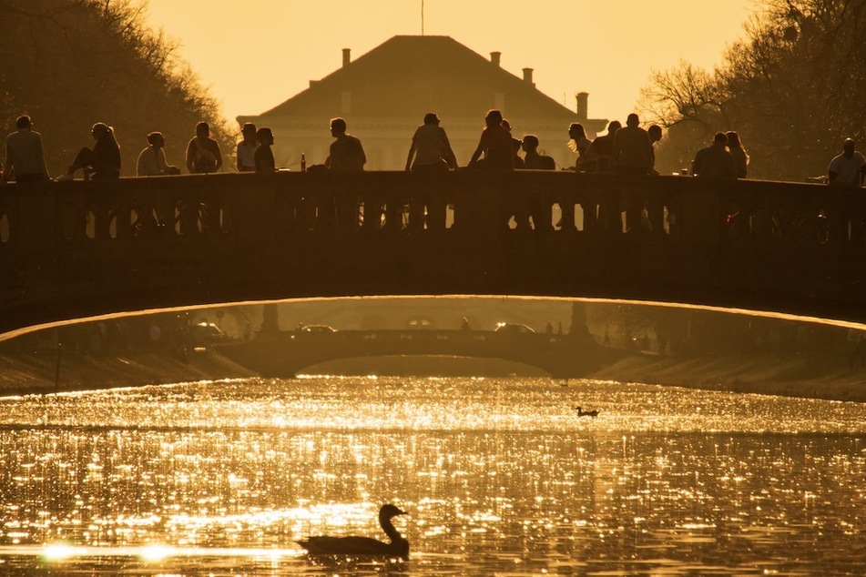 Zahlreiche Menschen sitzen an der Gerne Brücke in Nymphenburg und genießen den Frühlingsabend. Die Infektionszahlen sind in München weiter angestiegen.