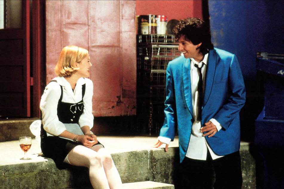 Drew Barrymore (l) and Adam Sandler (r) play a wedding singer and a hostess in the romantic comedy, The Wedding Singer.