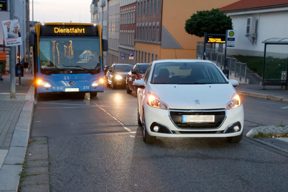 Das Kind rannte vor einem stehenden Bus auf die Straße.