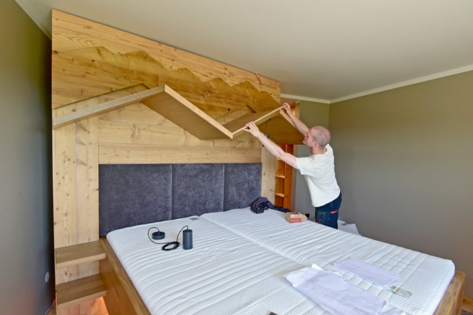 Im Musterzimmer montiert Kurt Knietzsch (19) eine Holz-Silhouette über dem Bett, die den Großen und den Kleinen Fichtelberg symbolisiert.