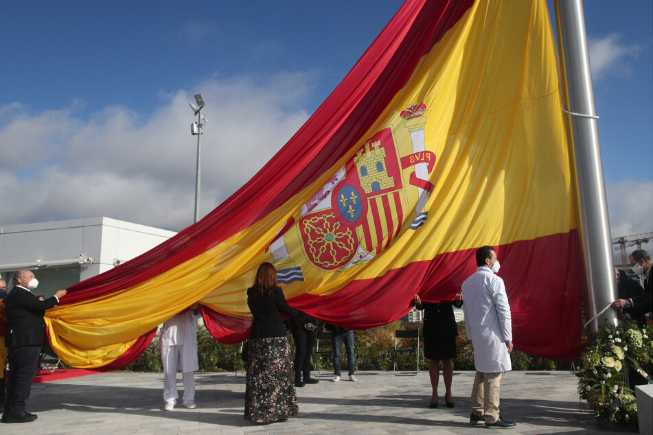 Während der Ehrung der Bevölkerung von Madrid in ihrem Kampf gegen die Corona-Pandemie wird die Nationalflagge gehisst. Im spanischen Corona-Hotspot Madrid gilt ab dem heutigen Samstag nach dem Ende der zweiwöchigen Absperrung der Hauptstadt eine "nächtliche Schließung" zwischen Mitternacht und 6 Uhr morgens.