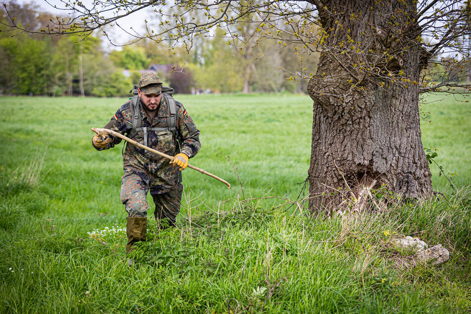 Ein Soldat der Bundeswehr sucht ein Feld nach Arian ab.