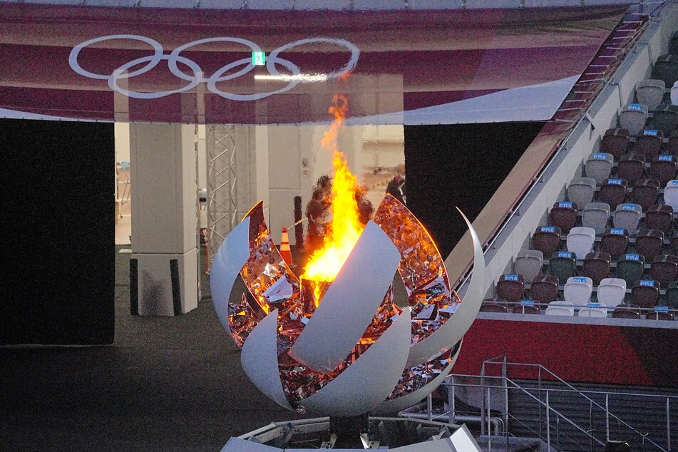 Das Olympische Feuer brennt vor der Abschlusszeremonie in Tokio. Die Spiele wurden immer wieder kritisiert, weil sie trotz der Corona-Pandemie stattfanden. Es gab zahlreiche Infektionen im Umfeld von Olympia.