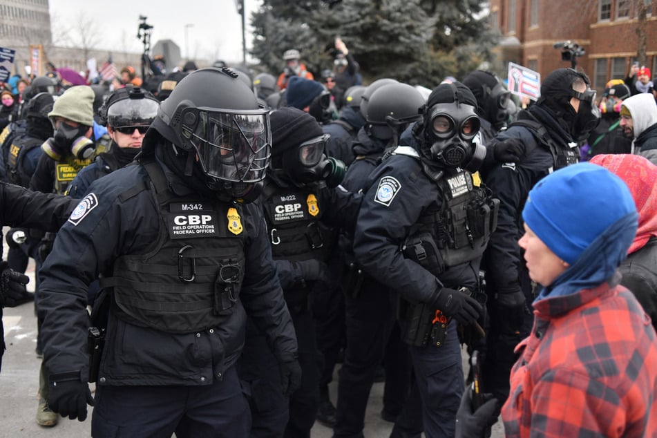 Federal agents confront anti-ICE protesters during a demonstration outside the Bishop Whipple Federal Building in Minneapolis, Minnesota, on January 15, 2026.