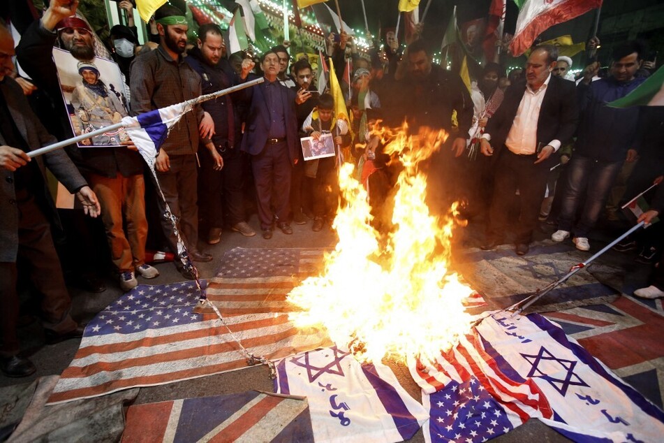 Iranians burn Israeli and US flags during a protest at Palestine square in Tehran, on April 1, 2024.