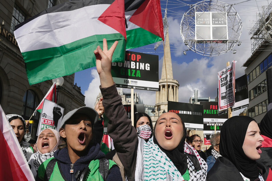 Zahlreiche Menschen halten Plakate während einer pro-palästinensischen Demonstration in London hoch.