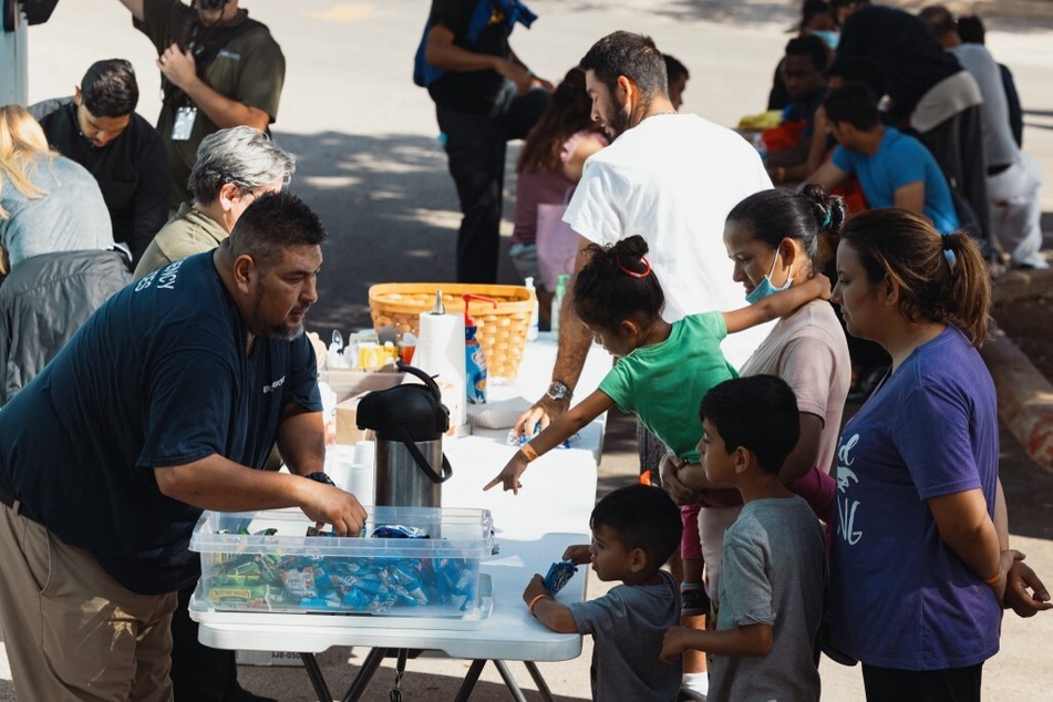Groups of migrants receive food from the San Antonio Catholic Charities outside the Migrant Resource Center in San Antonio, Texas – the place of origin of the two planes of migrants who were sent via Florida to Martha's Vineyard.