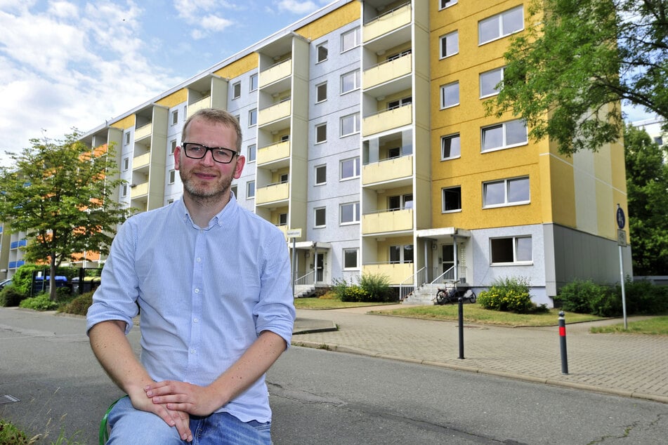 Stadtteilmanager Thomas Rosner (36) sitzt vor dem Plattenbau, in dessen Erdgeschosswohnungen die "Begehungen" stattfinden.