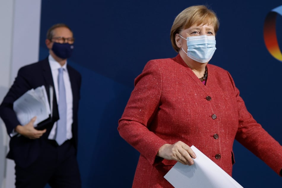 Bundeskanzlerin Angela Merkel (CDU, r) und Michael Müller (SPD), Regierender Bürgermeister von Berlin, verlassen nach einer Pressekonferenz einen Saal im Bundeskanzleramt.