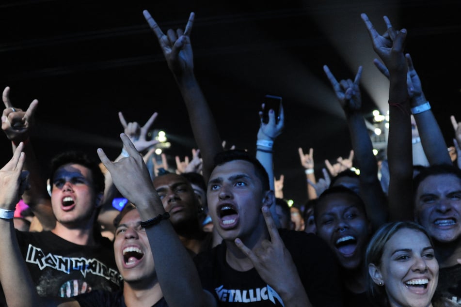 Fans of French heavy metal band Gojira attend their concert during the second day of the Rock in Rio music festival at the City of Rock park in Rio de Janeiro, Brazil, on September 19, 2015.