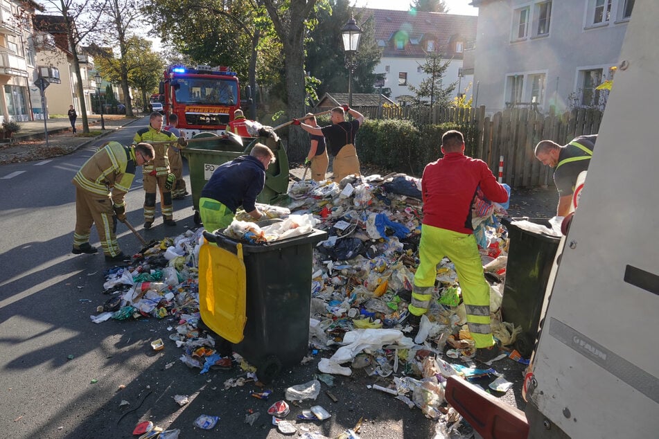 Gemeinsam mit den Mitarbeitern der Müllabfuhr bereinigte die Feuerwehr den Müllberg auf der Straße.