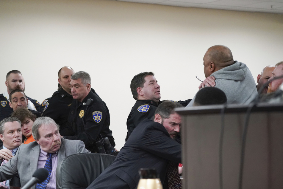 Der Mann im grauen Pullover versucht auf den angeklagten Attentäter von Buffalo loszugehen. Die Sicherheitskräfte können ihn stoppen.