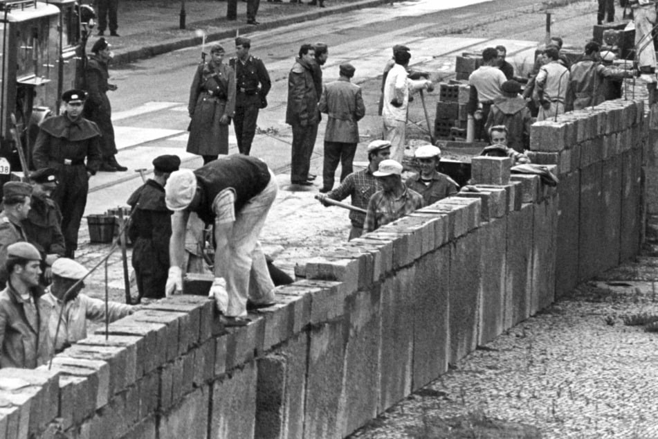 Beginn einer über 28-jährigen Teilung: Unter Aufsicht bewaffneter Volkspolizisten errichtet eine Ostberliner Maurerkolonne im August 1961 an der sowjetisch-amerikanischen Sektorengrenze am Potsdamer Platz eine mannshohe Mauer.