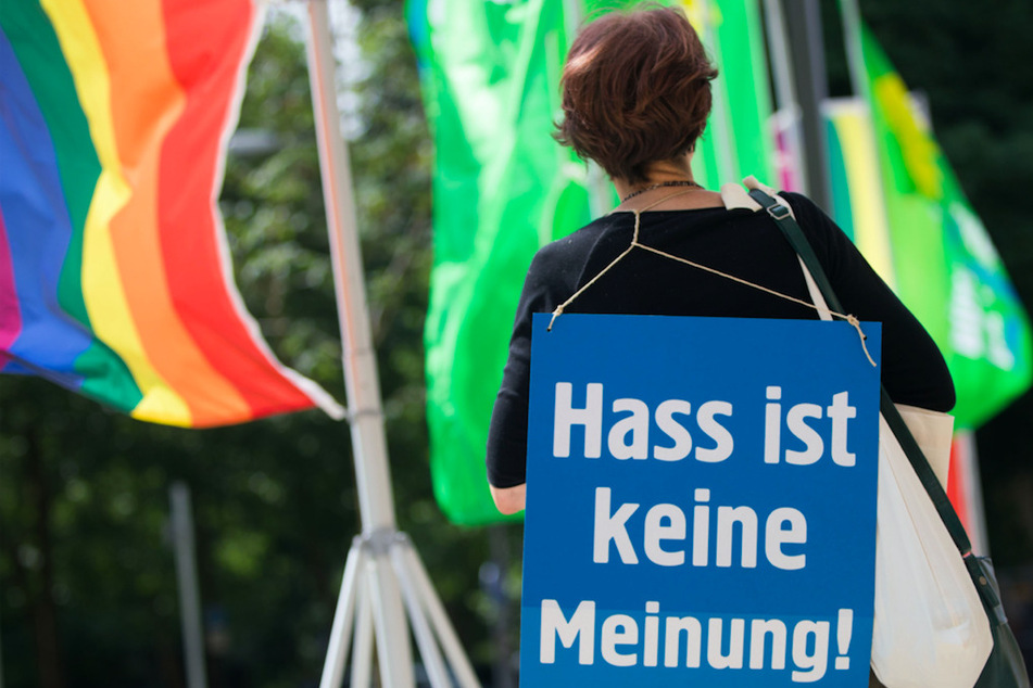 Eine Aktivistin hat ein Plakat mit der Aufschrift "Hass ist keine Meinung" über der Schulter. Gerade in der Pandemie haben Hass und Hetze zugenommen.
