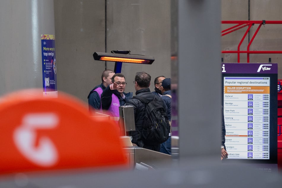 Mitarbeiter von V-Line helfen Kunden am Bahnhof Southern Cross in Melbourne.