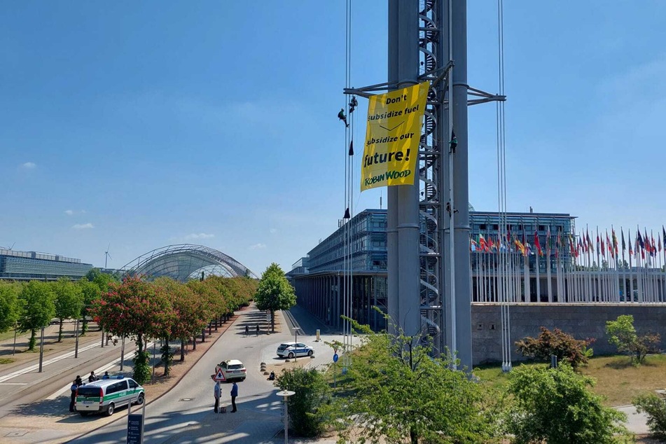 Kletterer der Umweltschutzorganisation Robin Wood haben zum Auftakt des Weltverkehrsforums ein riesiges Protestplakat an einem Turm der Leipziger Messe aufgehängt.