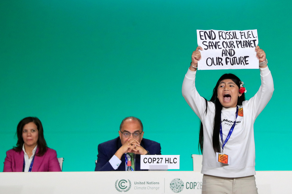 Licypriya Kangujam, an Indigenous climate activist from India, holds a banner calling for the end of fossil fuels during COP28 in Dubai.